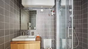 A modern bathroom with a sink, toilet, and glass shower enclosure. - New Apartment Boulogne Facing "les Passages" (Boulogne-Billancourt)