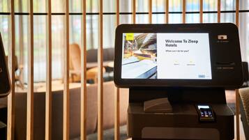 Een digitale kiosk met een scherm waarop een welkomstboodschap voor Zleep Hotels staat.