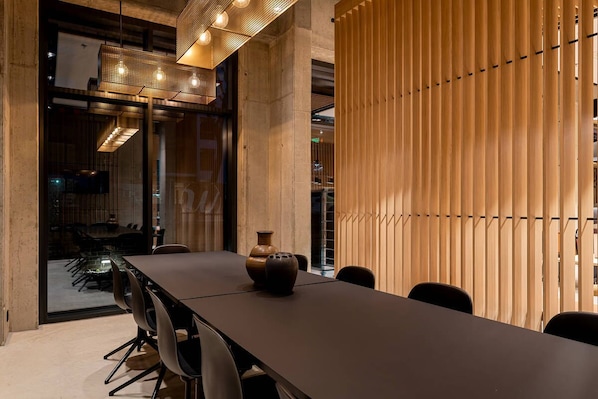 A modern conference room with a long table, chairs, and a decorative vase.