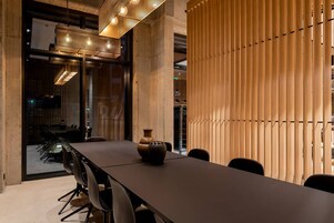 A modern conference room with a long table, chairs, and a decorative vase.
