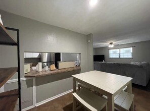 A compact living space with a kitchenette, a dining area, and a couch. - Conveniently Located 2-Bedroom Apartment Near Downtown Lawton (Lawton)