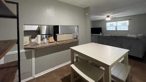 Un espacio habitable compacto con kitchenette, comedor y sofá.