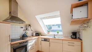 Una cocina con horno empotrado, estufa, ventana y pileta.
