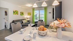 Et moderne hotelværelse med spiseplads, sofa og billeder på væggene.