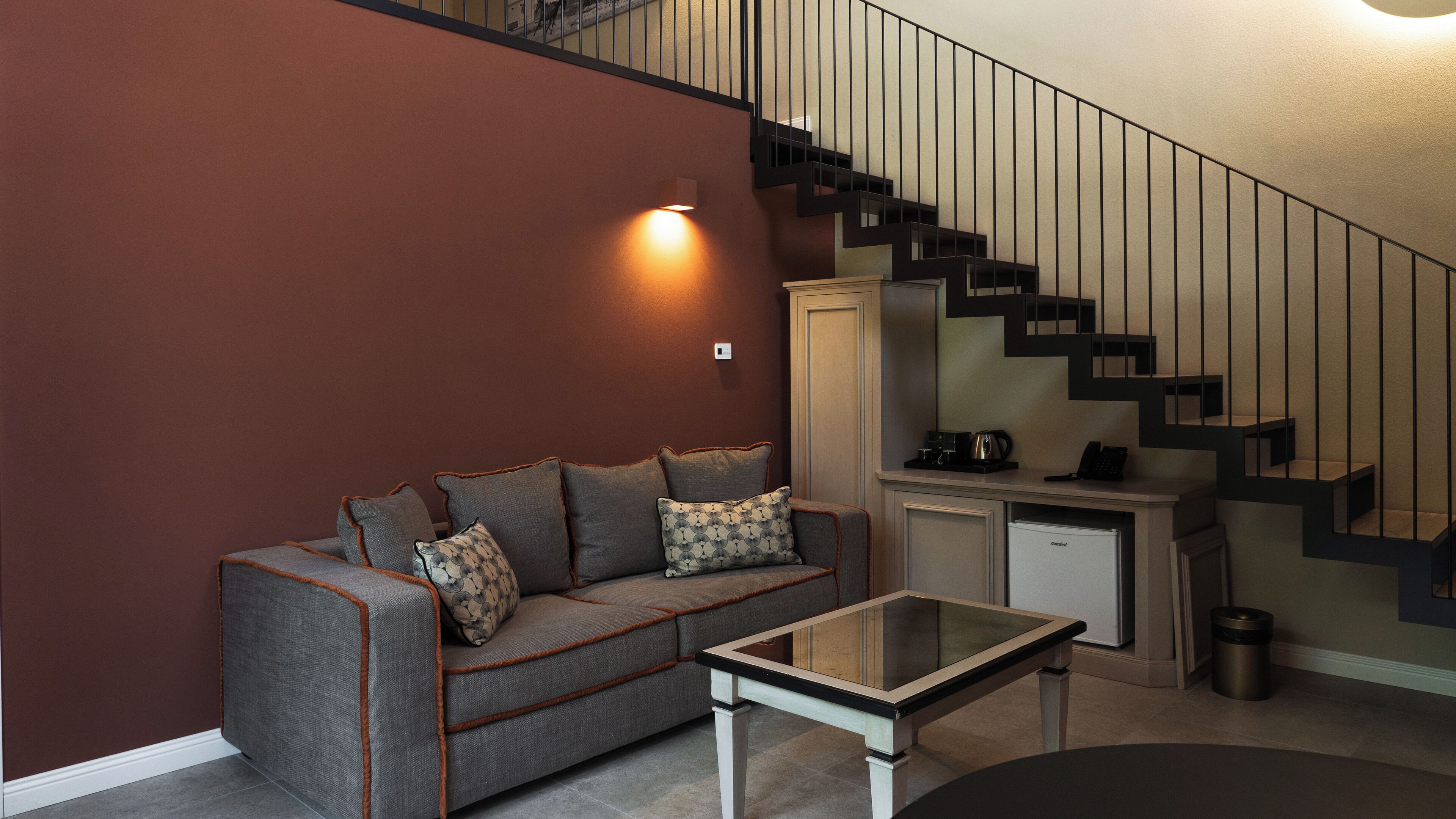 Una sala de estar moderna con un sofá, una mesa de centro y una escalera.
