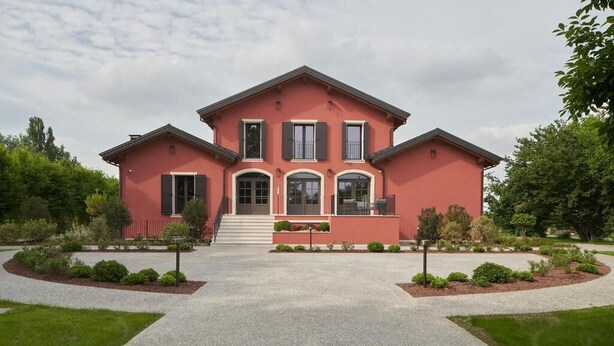 A two-story house with a symmetrical facade, a central entrance with steps, and a driveway leading to the front door. - Alle Siepi (Reggio nell'Emilia)