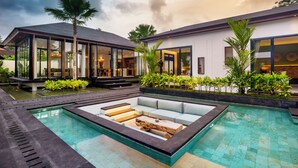 A modern house with a swimming pool, outdoor seating, and lush greenery. - Villa Lagoon by BaliSuperHost (Ubud)