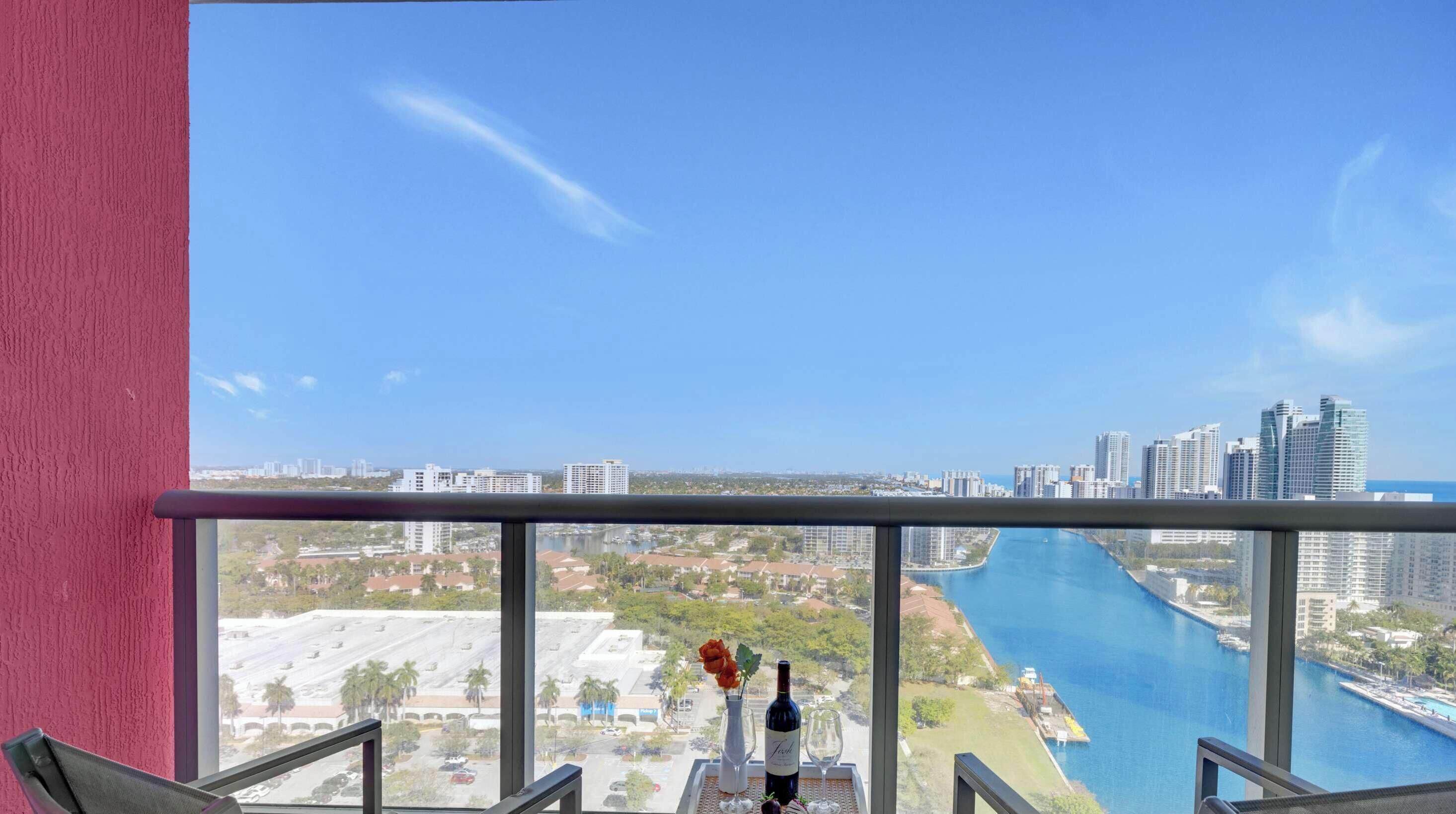 A balcony with a clear view of a river and cityscape.