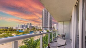 A balcony with a cityscape view, including high-rise buildings and a blue road. - Modern Resort - Pool & Amenities (Hallandale Beach)