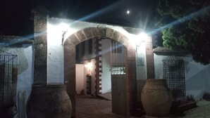An arched entrance with a metal gate, large vases, and a pathway leading to a building. - MOLINO DE LOS CARDENES 1911 (Montoro)
