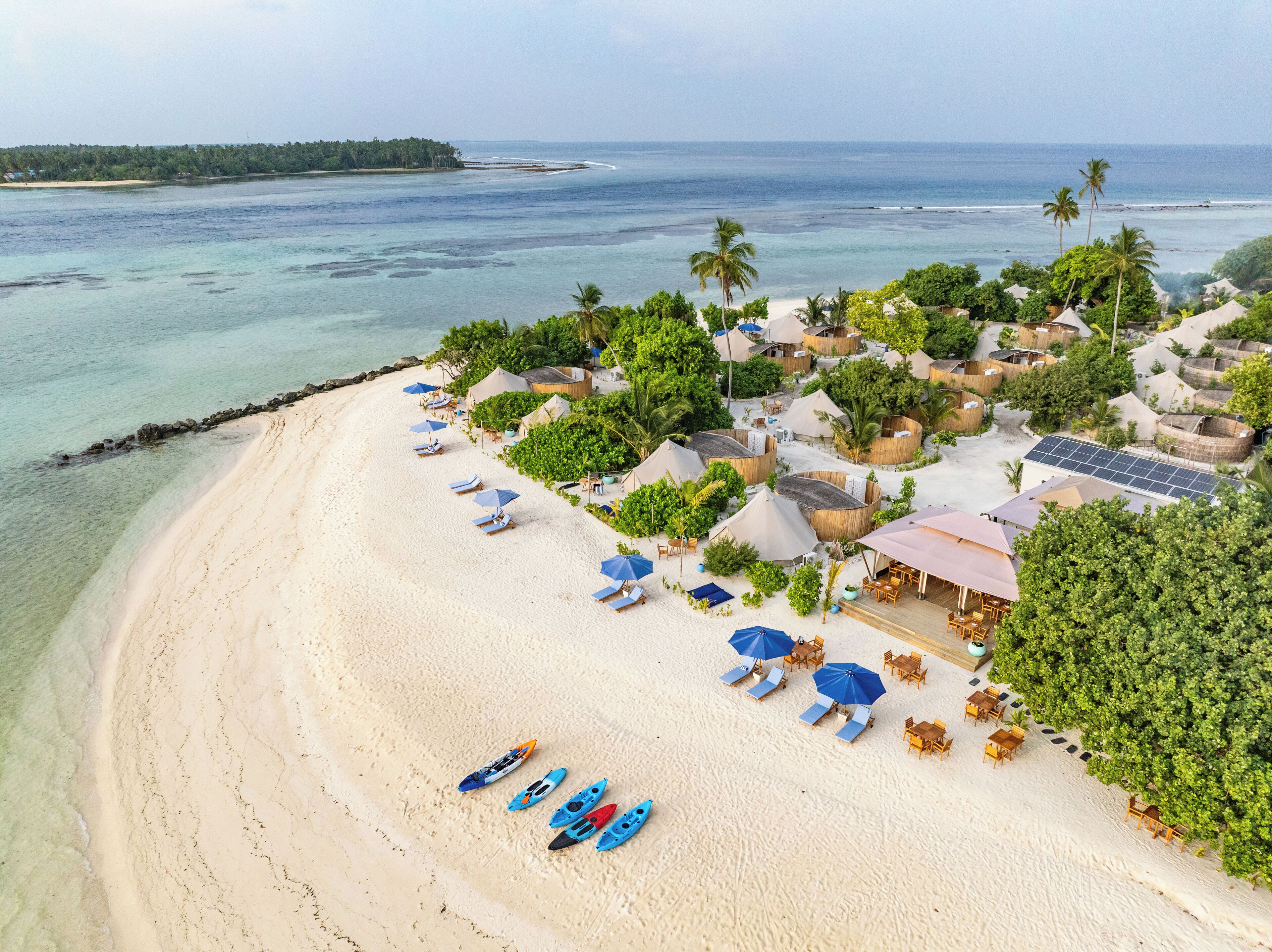 A beach resort with overwater bungalows, clear turquoise waters, and a sandy beach.