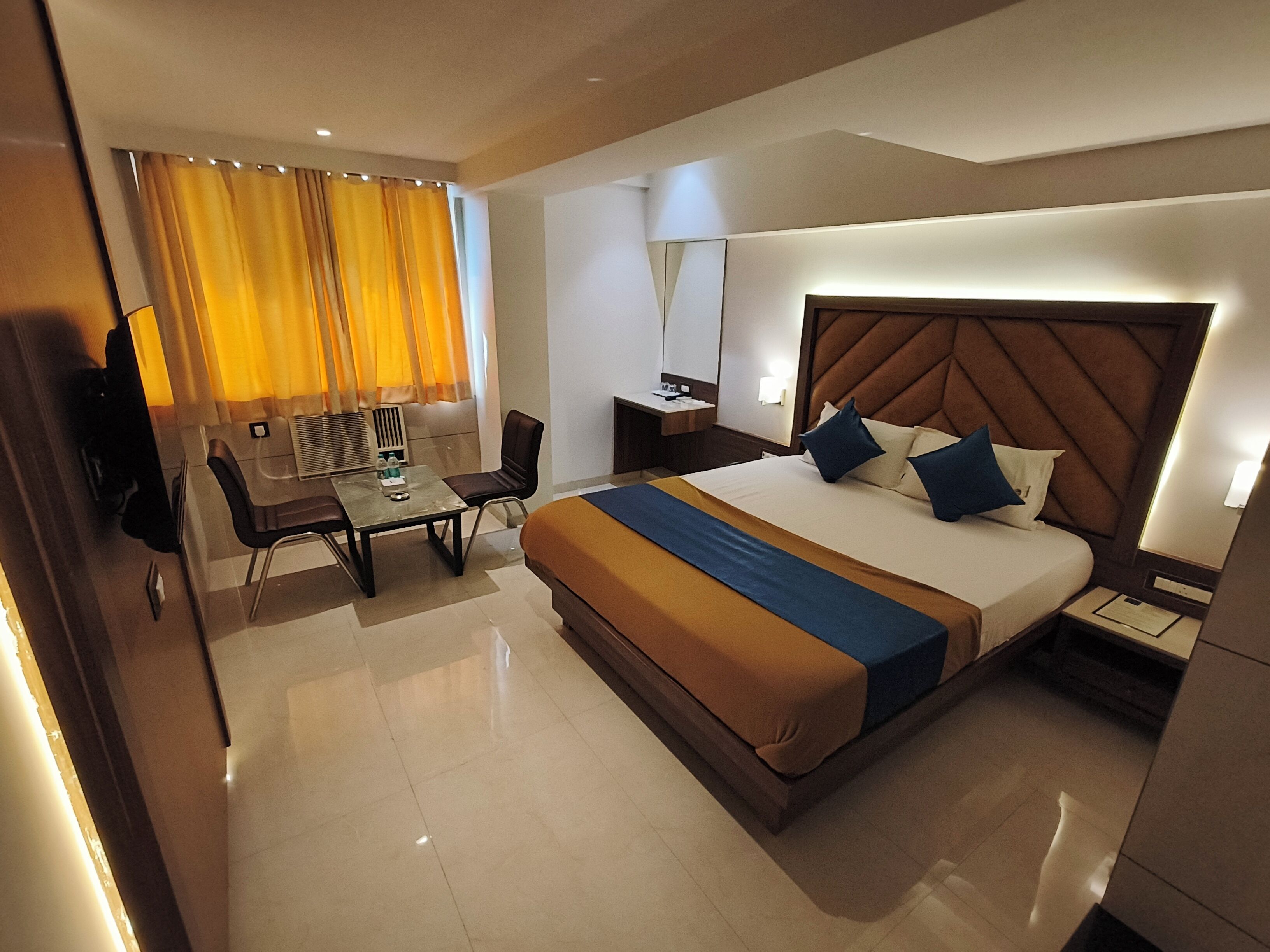 Una habitación de hotel con una cama, un escritorio y una silla.