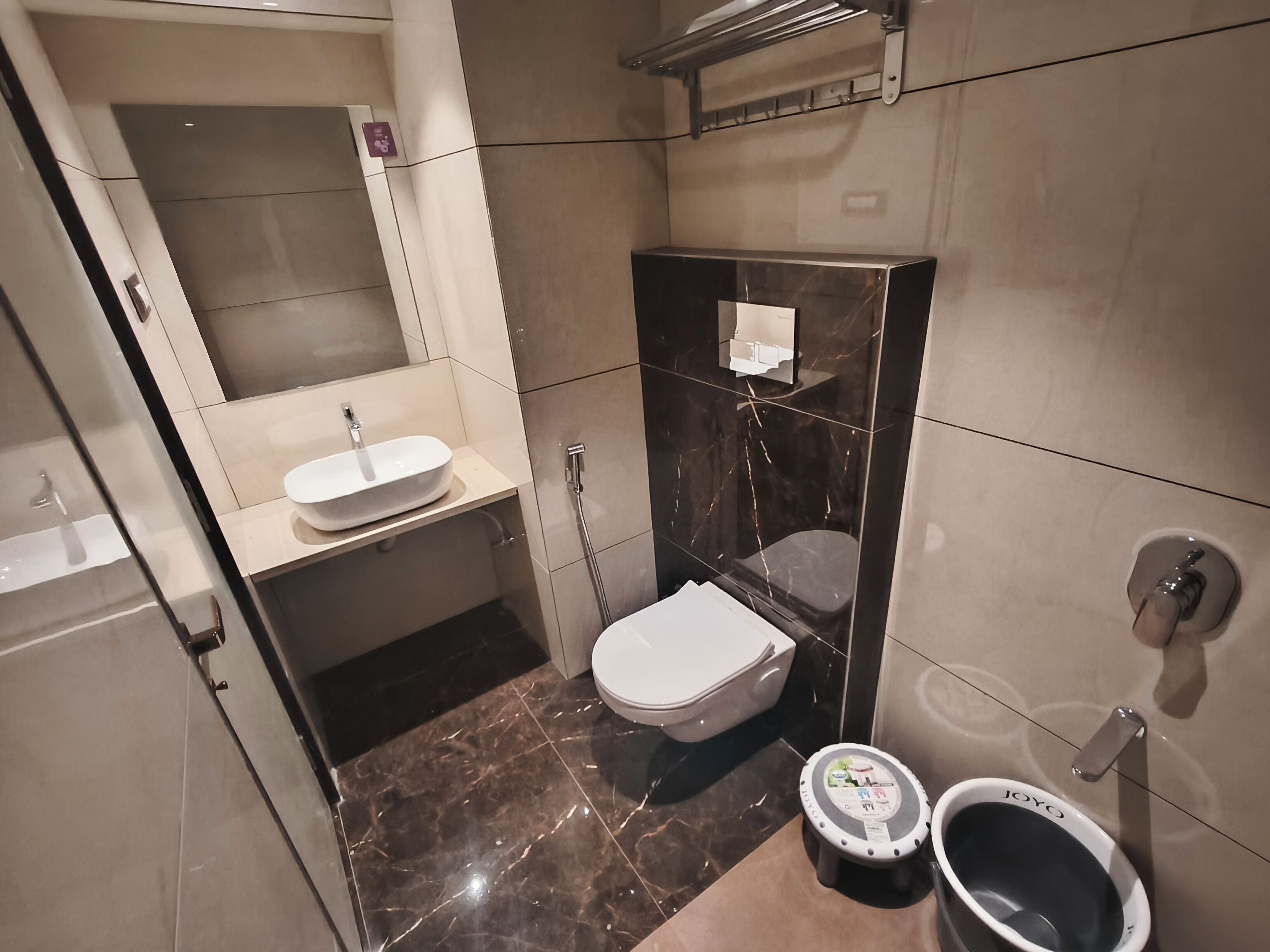 A compact bathroom with a sink, toilet, and shower.