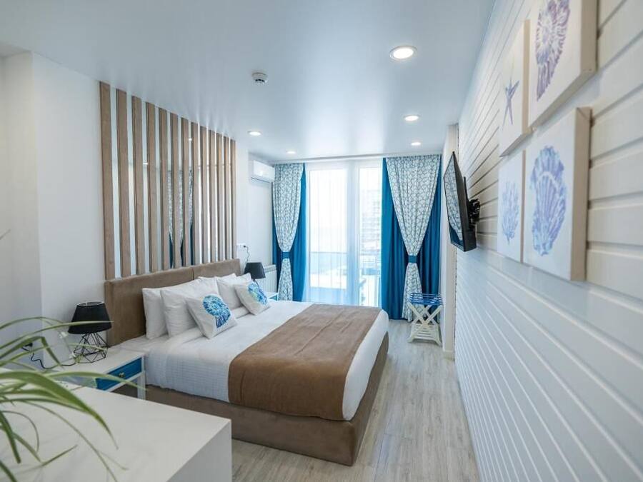 Minibar, tabla de planchar con plancha, ropa de cama