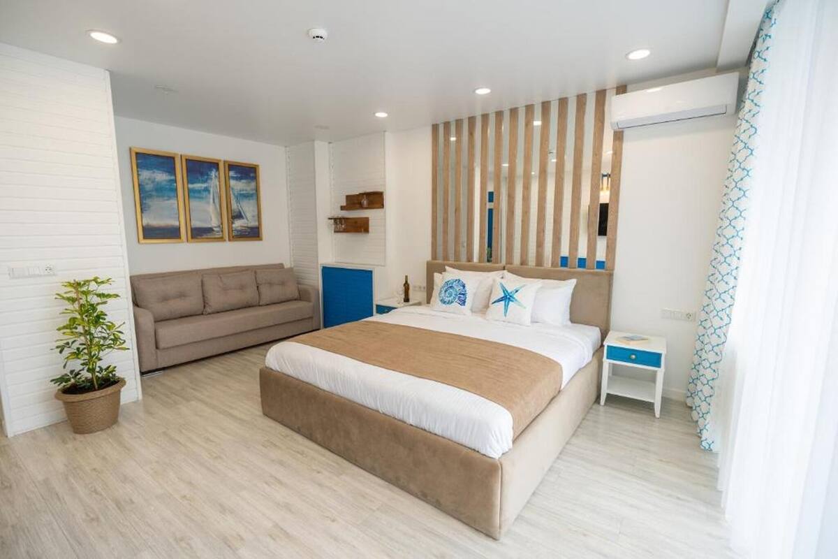 Deluxe tweepersoonskamer, balkon, gedeeltelijk uitzicht op zee | Een minibar, een strijkplank/strijkijzer, beddengoed