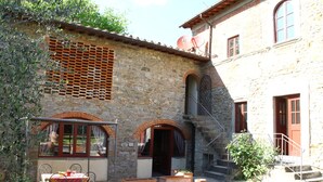 A stone building with a courtyard, outdoor seating, and a satellite dish. - Holiday Home in Reggello (Reggello)