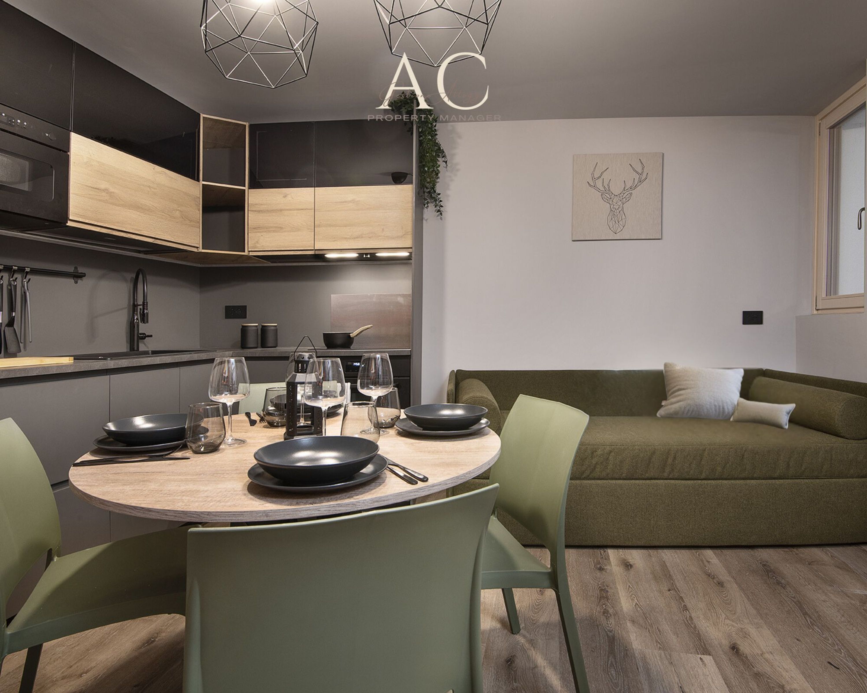 Eine moderne Küche mit Essbereich, ausgestattet mit einem runden Holztisch, grünen Stühlen und einem grünen Sofa.