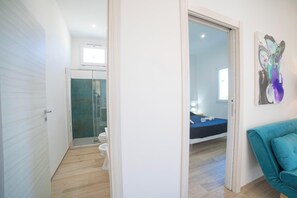 A modern bathroom with a glass shower enclosure, a toilet, and a sink.