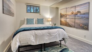 A bedroom with a bed, a nightstand, a lamp, and a window with blinds. - Walker’s Delight on Queen Anne (Seattle)