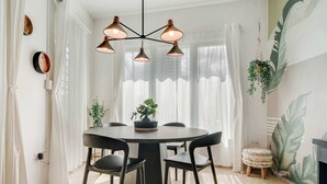 A dining area with a round table, black chairs, and a ceiling light fixture.