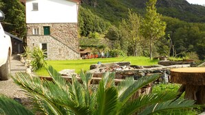 Un edificio de dos pisos con fachada de piedra y una ventana pequeña.