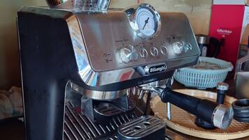 A coffee machine with a digital display, a steam wand, and a portafilter.