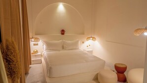 A bedroom with a bed, bedside tables, a lamp, and a vase on a shelf. - Luxury 2BHK Escape w/ Hot Tub, Free Wi-Fi, AC (Kathmandu)