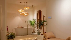 A modern bathroom with a freestanding bathtub, a large mirror, and a vanity. - Luxury 2BHK Escape w/ Hot Tub, Free Wi-Fi, AC (Kathmandu)