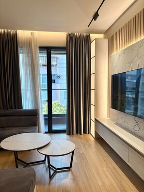 Appartement, balkon | Woonruimte | Een 32-inch flatscreentelevisie met kabelzenders