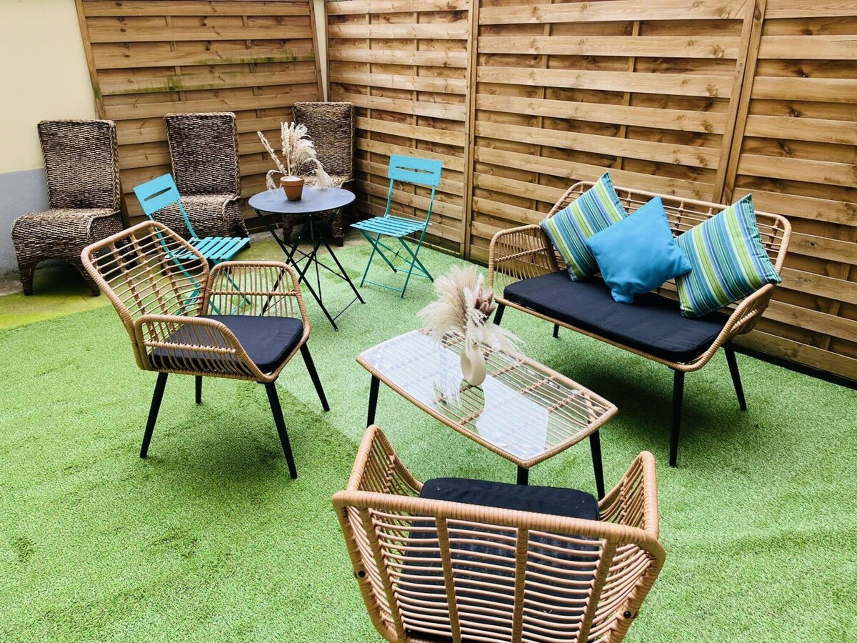 A patio area with wicker furniture, a round table, and a small decorative plant.