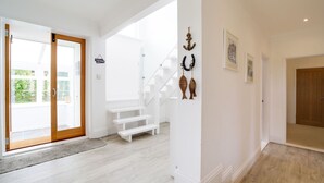 A modern interior with a staircase, white walls, and a wooden floor.
