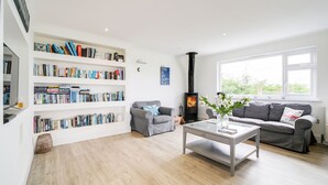 A modern living room with a fireplace, bookshelves, two sofas, and a coffee table.