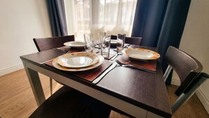 A dining table set with plates, glasses, and cutlery. - Mountain Paradise 2 - Cosy 2 Bed Mountain View Apartment - Washer (Bansko)