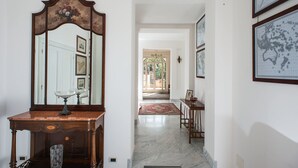 Un pasillo con una mesa de madera, un espejo y un tapete rojo.