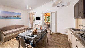 A compact living space with a sofa, dining table, and kitchenette. - Farmhouse in Vieste Near Gargano Coast (Vieste)