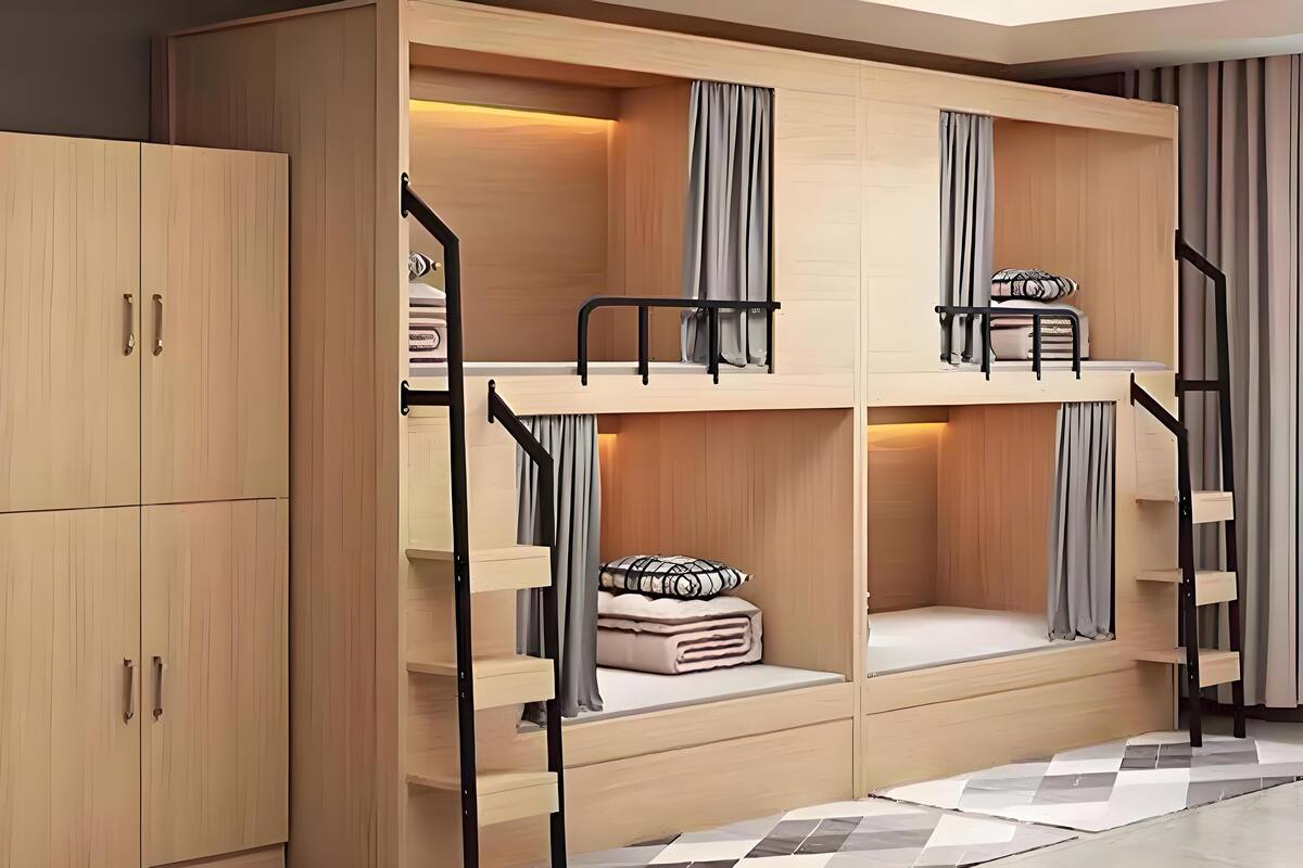 Une chambre avec un lit superposé, une armoire en bois et un sol à carreaux.
