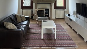 Una sala de estar con chimenea, un sofá, una mesa de centro y un televisor.