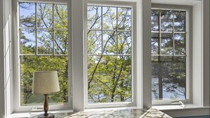 A room with a marble table and a lamp, large windows with a view of trees and water. - Peaceful Riverfront Hideaway | 4BR/3BA | Wildlife, Views & Deep Water Dock (Edgecomb)