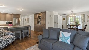A modern kitchen with a central island, wooden cabinets, and stainless steel appliances. - Peaceful Riverfront Hideaway | 4BR/3BA | Wildlife, Views & Deep Water Dock (Edgecomb)