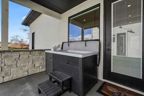 Un bagno esterno moderno con parete in pietra, una panca e un'ampia finestra.