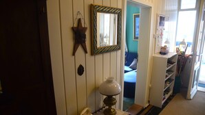 A hallway with a telephone, a lamp, a mirror, and a star decoration on the wall.