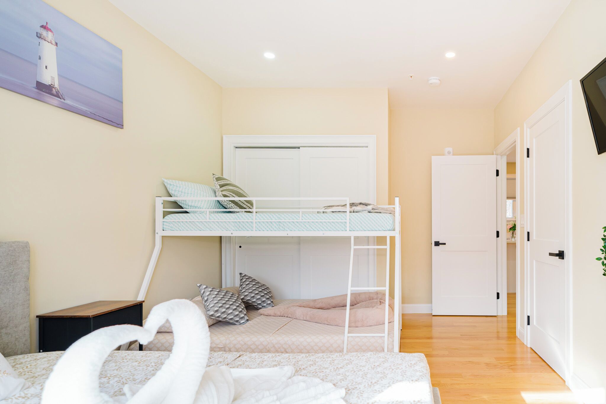 Un dormitorio con literas, un escritorio, una silla, un armario y un televisor.