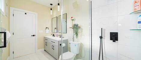 Une salle de bain moderne équipée de toilettes, d’un lavabo et d’une douche.