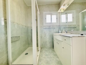 A bathroom with a shower, a sink, and a mirror. - HORIZONTE AZUL. Frente al mar en la Playa de la Almadraba – Roses (Roses)