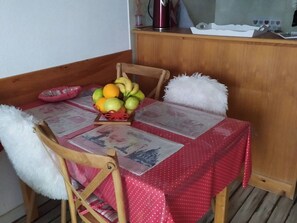 A dining table with a red tablecloth, a fruit basket, and a newspaper. - F2 by slopes with WiFi and parking (Les Angles)