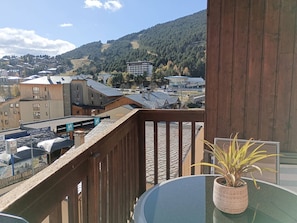 Un balcón con vistas a un pueblo y montañas.