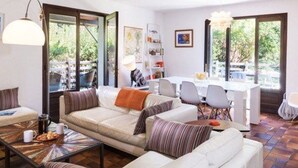 A modern living room with a sofa, coffee table, and dining area. - Peaceful villa with heated pool and Wi-Fi (Lège-Cap-Ferret)