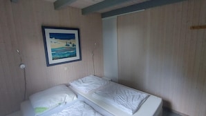 A room with a bed, a painting on the wall, and wooden paneling. - Ferienhaus im Skandinavischen Stil (Mirow)