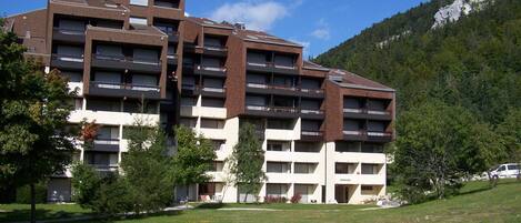 A multi-story hotel with a modern architectural design, featuring balconies and a flat roof.