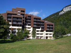 A multi-story hotel with a modern architectural design, featuring balconies and a flat roof. - Studio for 4 pers at slopes' foot with south-facing balcony, parking (Corrençon-en-Vercors)